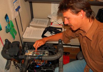 Alex pointing at a bike gadget.JPG