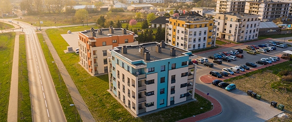 An aerial view of a multifamily housing complex next to a road