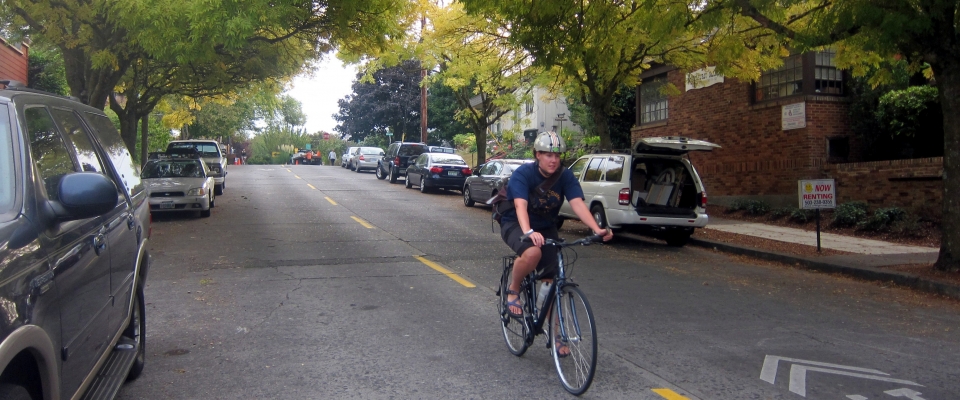 A bicyclists rides down a neighborhood greenway