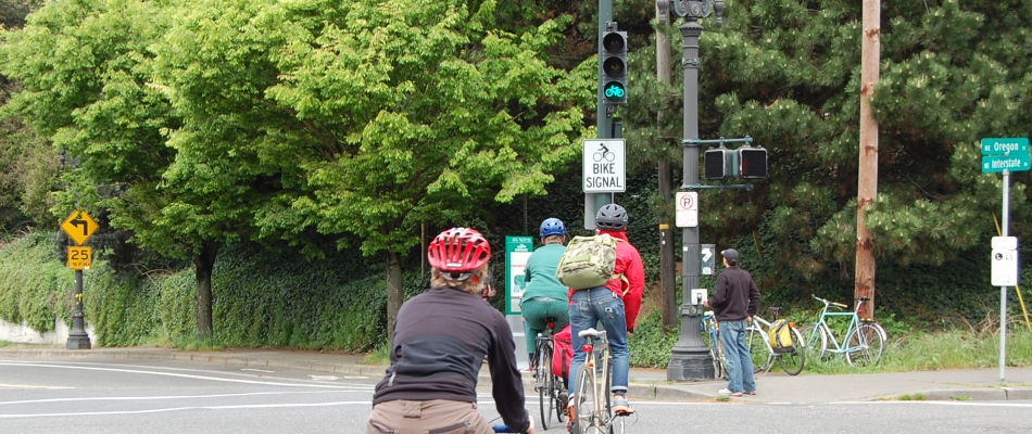 Cyclists riding toward a green bike signal