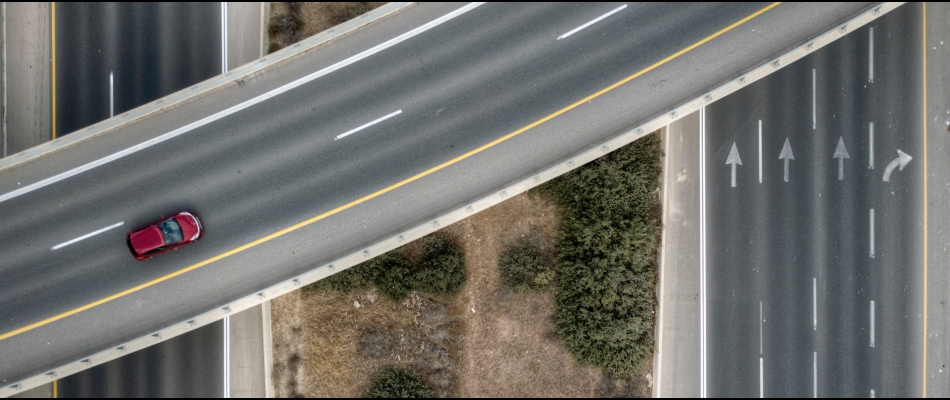 A red car travels along a highway